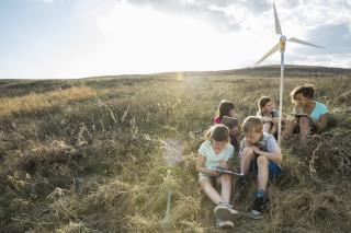 Schoolchildren discussing notes on wind turbine 